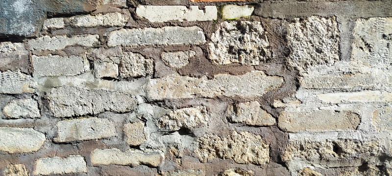 Primer plano de una textura de muro de piedra antigua y rugosa