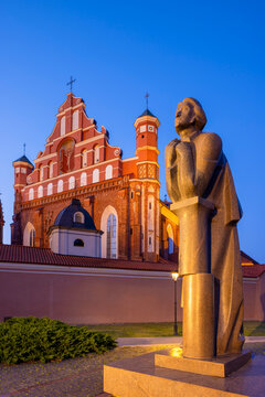 A Statue of the Polish Poet Adam Mickiewicz in front of St. Anne's Church and the Church of St. Francis and St. Bernard at Dusk, Vilnius, Lithuania