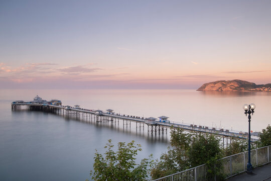 Llandudno Pier and the Little Orme from the Promenade at sunset, Llandudno, Conwy County Borough, North Wales, UK