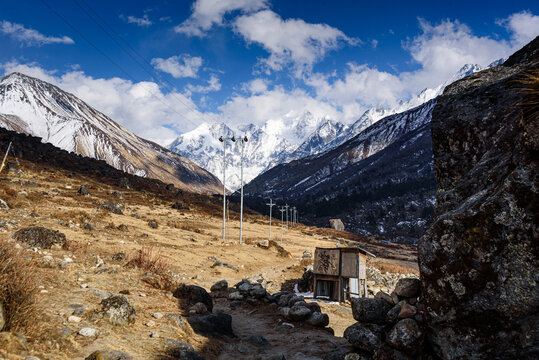 Small shelter and prayer flags along mountain path with stunning view of snow-covered Gangchempo, Langtang Himalay, Nepal
