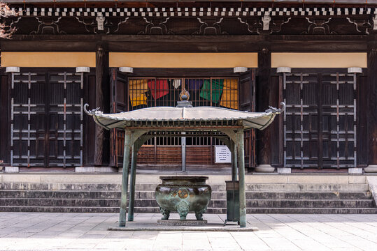 Front view of Chion-in Temple&acirc;&euro;&scaron;Ă&bdquo;Ă&acute;s main hall in Kyoto, featuring dark wooden architecture, a traditional incense burner, and multicolored Buddhist banners