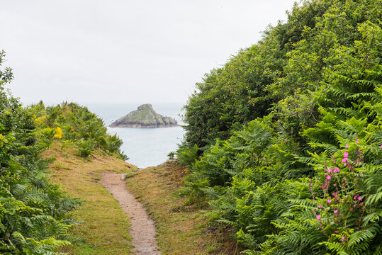 Trail on the west coast with Jethou Island in the distance, Herm Island, Bailiwick of Guernsey, United Kingdom