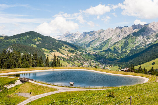 Reservoir, high mountain pasture of Corbassieres in Beauregard range with Aravis range in the background, near La Clusaz, Haute-Savoie department, Rhone-Alpes region, France, Europe