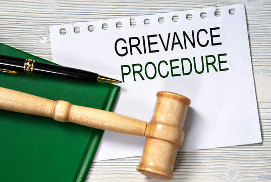 GRIEVANCE PROCEDURE - words in white paper against the background of a green folder and a judge's gavel