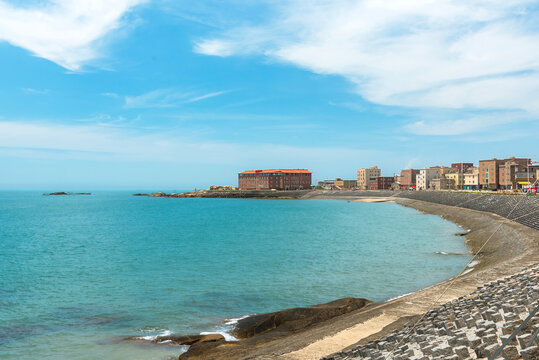 Seaside view of Little Weihai town with clear blue water and buildings along the shore in Quanzhou, Fujian Province, China