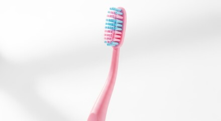 Pink toothbrush with blue bristles against a white background