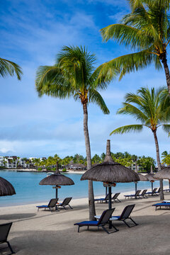 Beach with sun beds and umbrellas in Le Touessrok resort, at Trou d'Eau Douce, on the exotic island of Mauritius in the Indian Ocean