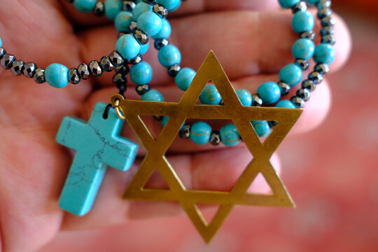 Two monotheistic religions, Christianity and Judaism. A rosary and a star of David. Religious symbols.