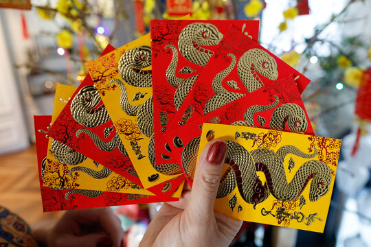 Asian woman with red envelopes ( hongbao ) for Chinese and Vietnamese New Year celebration. Red color is a symbol of good luck. Year of the snake.