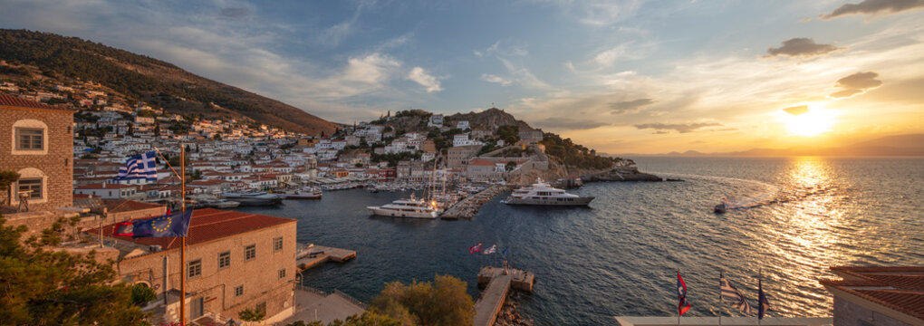 Panoramic view over the port and whitewashed houses on hillside at sunset, Hydra, Saronic Islands, Greek Islands, Greece, Europe