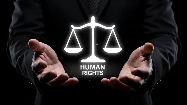 4K footage Close-up of a person in a suit holding glowing scales of justice with 'HUMAN RIGHTS' text, conveying truth and dignity in a dark background with cinematic lighting.