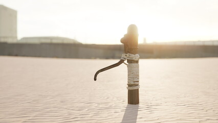 A wooden post stands firmly in the sandy ground, wrapped with rope, as the sun sets, casting a warm light that enhances the serene atmosphere of the scene. © icetray
