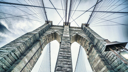 Obraz premium Brooklyn Bridge stone pillars captured from below highlighting structural details and grandeur