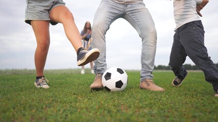 Obraz premium Family playing with soccer ball. Children playing soccer with their families in nature. A dad and kids are playing ball in a park. A family having fun with a soccer ball lifestyle.