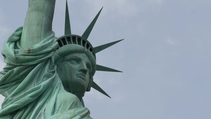 Statue of Liberty on Liberty Island, New York, United States. Blue cooper monument, symbol of democracy and patriotism near Manhattan, NYC USA. Clouds on sky. American independence. Torch and crown.