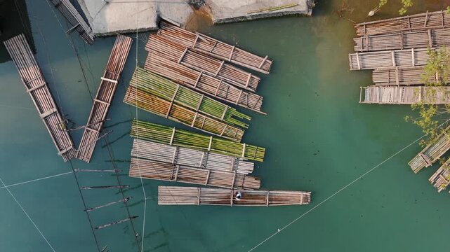 Aerial view of a bamboo raft on the emerald green River in Hang Than Lim, Yen Minh, Ha Giang, Vietnam. Local villagers use the bridge to transport tourists.