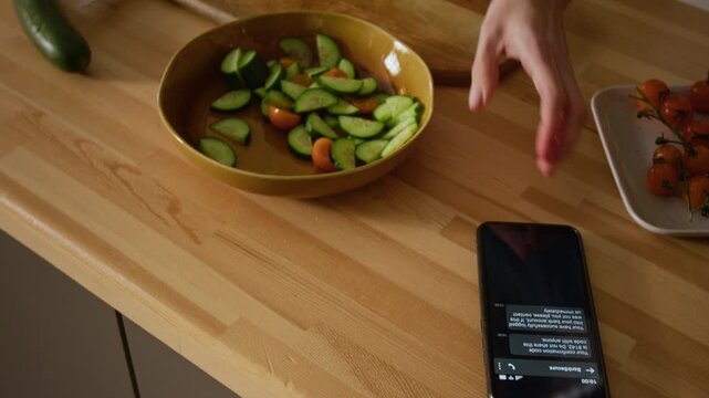 Medium close-up of smartphone with scam money withdrawal messages on kitchen table, woman picking up, staring with shock and disbelief, frantically calling support or police and crying in despair