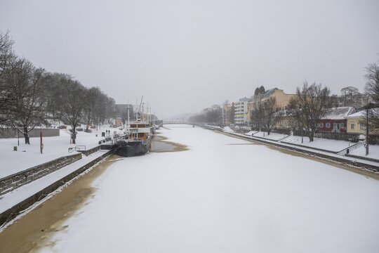 Ships moored on the banks of the frozen Aurajoki River, wintery Turku or Swedish &Aring;bo, Varsinais-Suomi, Finland