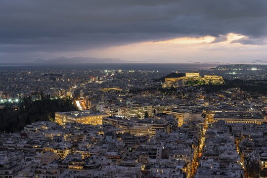 View over the sea of houses of Athens, illuminated Parthenon temple on the Acropolis, from Mount Lycabettus, Athens, Greece