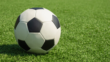 Fototapeta premium Soccer ball on green grass field close up