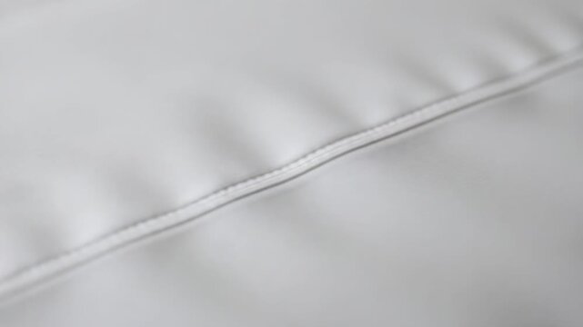 Macro stock video of pillow corner seam, slow slider move and rack focus for premium textile detail 4KAI video pillow seam macro, fabric texture and clean stitching 4K. High quality FullHD footage