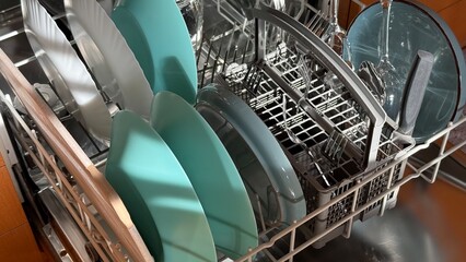 Dishwasher finished cycle, cleaned plates white blue, home real UGC shot, cutlery glasses mug cup kitchen sparkling 
