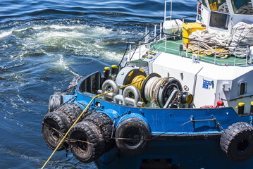 Detailed view of a tugboat’s bow winch and line during ship mooring maneuvers in Mejillones harbor, Chile. © Mariusz
