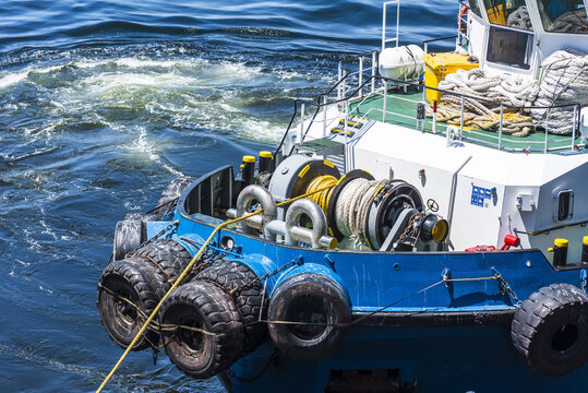 Detailed view of a tugboat&rsquo;s bow winch and line during ship mooring maneuvers in Mejillones harbor, Chile.