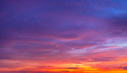 Dramatic sunset sky with vibrant orange and purple clouds at twilight,A breathtaking panoramic view of a colorful sunset sky featuring a mix of fiery orange, deep purple, and blue hues.