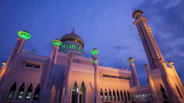Breathtakiong slow motion shot of Omar Ali Saifuddien Mosque at twilight with illuminated minarets. Southeast Asian tourism, Islamic heritage documentaries, and architectural appreciation.