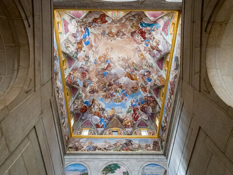 View of vibrant frescos and ornate details adorn the vaulted ceiling, a symphony of color and artistry in San Lorenzo de El Escorial, Comunidad de Madrid, Spain.