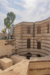 Historic circular brick structure in Coptic Cairo showcasing layered stone architecture and ruined courtyard