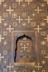 Decorative carved wooden shutter with geometric inlay patterns in historic Cairo interior