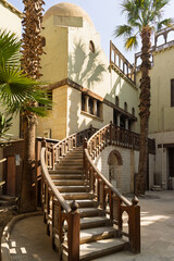 Curved wooden staircase and courtyard architecture at the Coptic Museum in Cairo, historic museum exterior