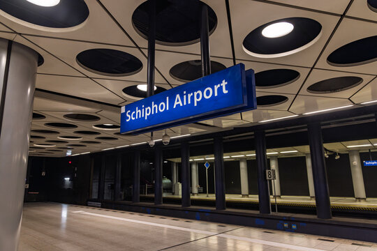 Interior of the Schiphol Airport underground train station with a blue station sign and distinctive circular ceiling design, Schiphol, Netherlands. 8 February 2026.