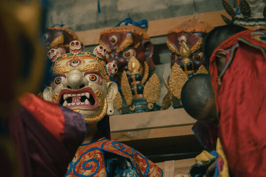 Jakar, Bhutan - 24 September 2025: View of ornate, colorful masks with intricate details and golden accents, standing out against the shadowed interior of Jakar Dzong.