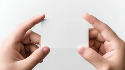 Obraz premium Two Hands Holding a Blank Card Against a Soft Neutral Background for Creative Use