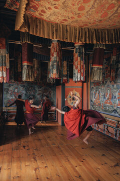 Jakar, Bhutan - 24 September 2025: View of monks gracefully swirling in a dance, their crimson robes a vibrant contrast against the painted walls of Jakar Dzong.