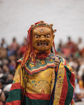 Thimphu, Bhutan - 28 September 2025: View of a vibrant mask dancer in traditional attire, embodying the rich cultural heritage against a backdrop of onlookers.