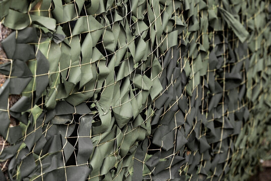A camouflage net with green ribbons attached to the net. Camouflage during combat operations. Texture. Banner.