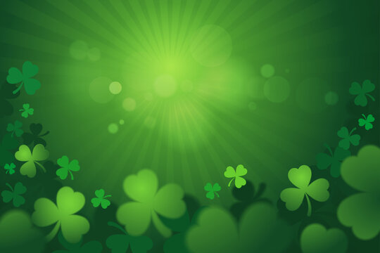 St. Patrick's Day background with green shamrocks and glowing light rays.