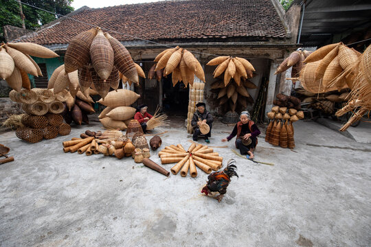 Hung Yen, Vietnam - 15 December 2019: View of handcrafted bamboo fish traps, drying in the sun, cast intricate shadows on the textured concrete, a testament to local artistry.