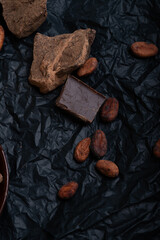 different various  of chocolate with natural cocoa beans at black background