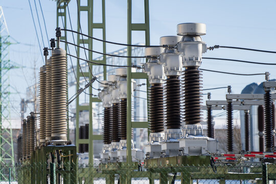 Electric power substation equipment with tall insulator stacks, disconnect switches and conductors, utility grid technology and energy security concept background