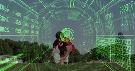 Crouching teen athlete wearing red jersey placing white ball on suburban field, with green HUD