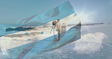 Naklejka premium Walking couple wearing sundress and patterned shirt along wet sand to horizon, flag overlay tinting