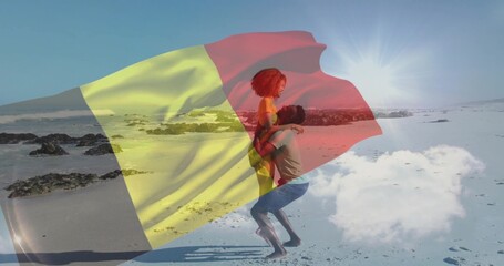 Naklejka premium Lifting couple wearing yellow one-piece and T-shirt with shorts on pale sand, flag overlay