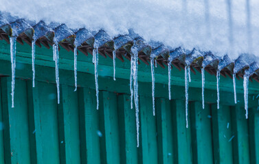 Icicles on the roof of the house. Danger of falling