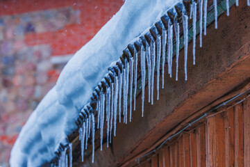 Icicles on the roof of the house. Danger of falling