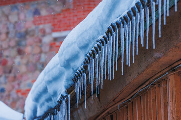 Icicles on the roof of the house. Danger of falling